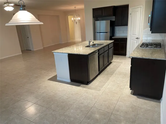 a kitchen with granite countertop a sink and a stove