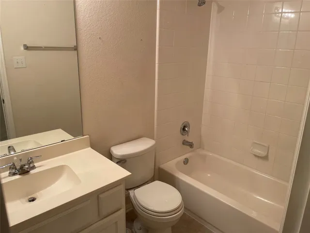 a view of a kitchen with granite countertop a sink a counter top space and cabinets