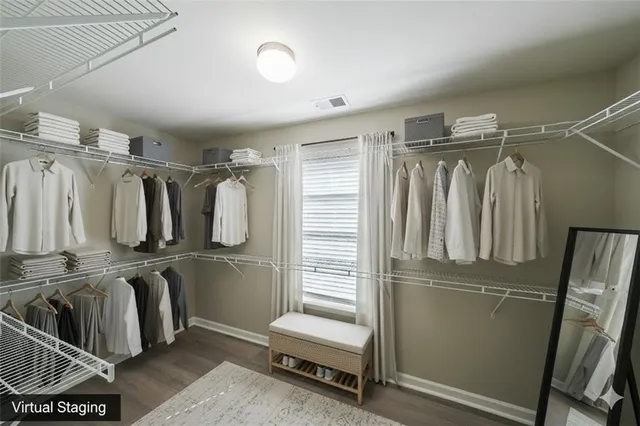 a view of walk in closet with clothes and shoes