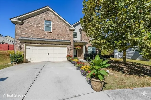 a front view of a house with a yard and a garden