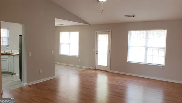 a view of a livingroom with a window and wooden floor