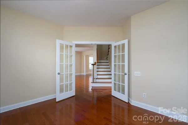 an empty room with fireplace cabinet and windows