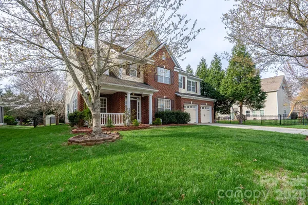 a front view of a house with a yard porch and trees