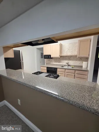 a kitchen with stainless steel appliances granite countertop a sink a stove and a refrigerator