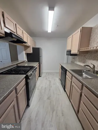a kitchen with granite countertop a sink stove and refrigerator