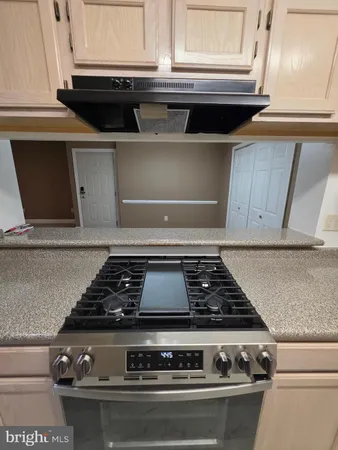 a stove top oven sitting inside of a kitchen