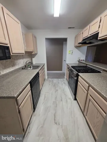 a kitchen with granite countertop a sink stove and refrigerator