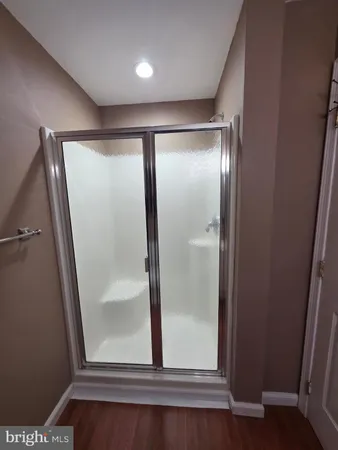 an empty room with wooden floor and mirror