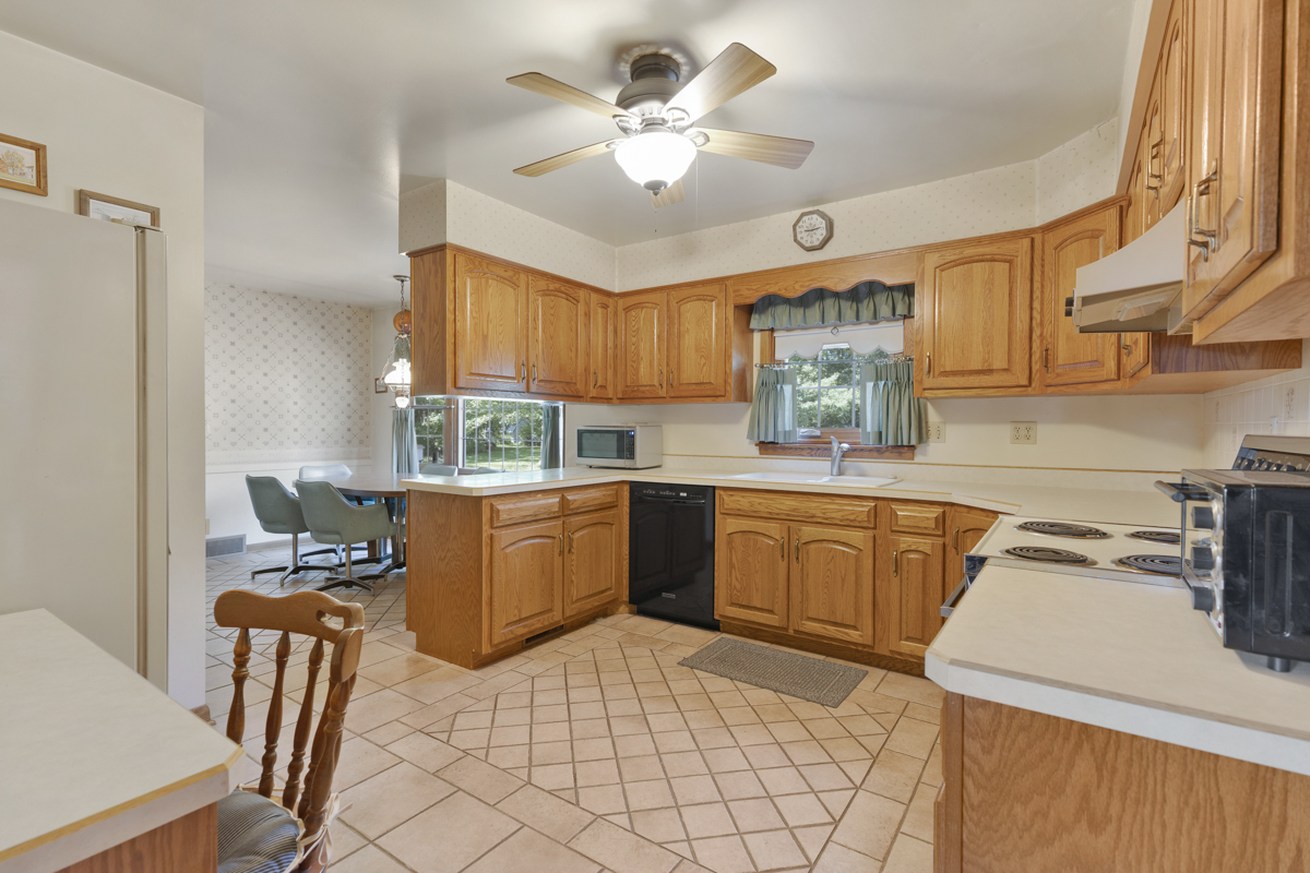 690 Stanford Drive Marengo, IL 60152 - Photo 9 of 30 a kitchen with granite countertop a stove a sink dishwasher and a refrigerator with wooden cabinets
