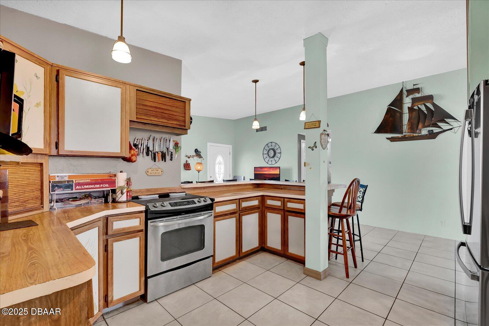 34 Dolphin Avenue Ormond Beach, FL 32176 - Photo 12 of 52 a kitchen with stainless steel appliances granite countertop a stove a sink and a refrigerator