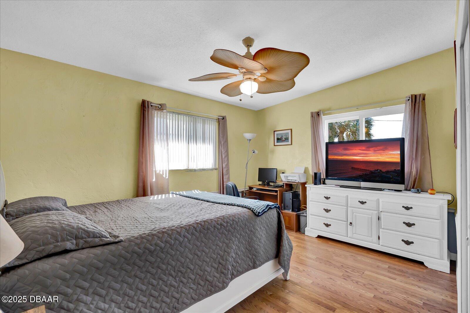 34 Dolphin Avenue Ormond Beach, FL 32176 - Photo 20 of 52 a bedroom with a flat screen tv on dresser and a chandelier