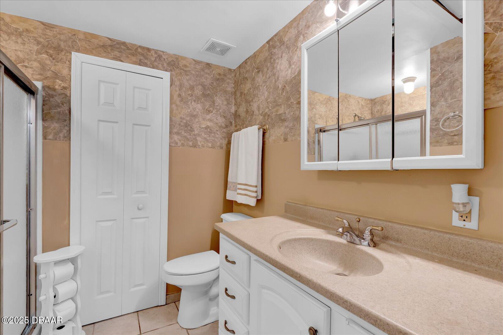 34 Dolphin Avenue Ormond Beach, FL 32176 - Photo 22 of 52 a bathroom with a granite countertop toilet a sink and a mirror