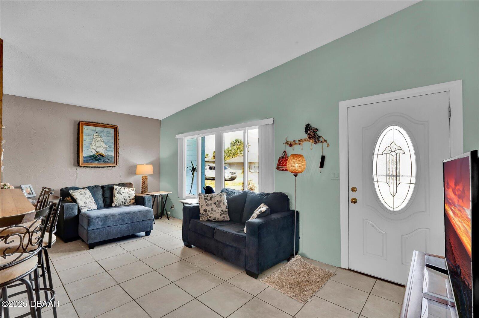 34 Dolphin Avenue Ormond Beach, FL 32176 - Photo 8 of 52 a living room with furniture a mirror and a window