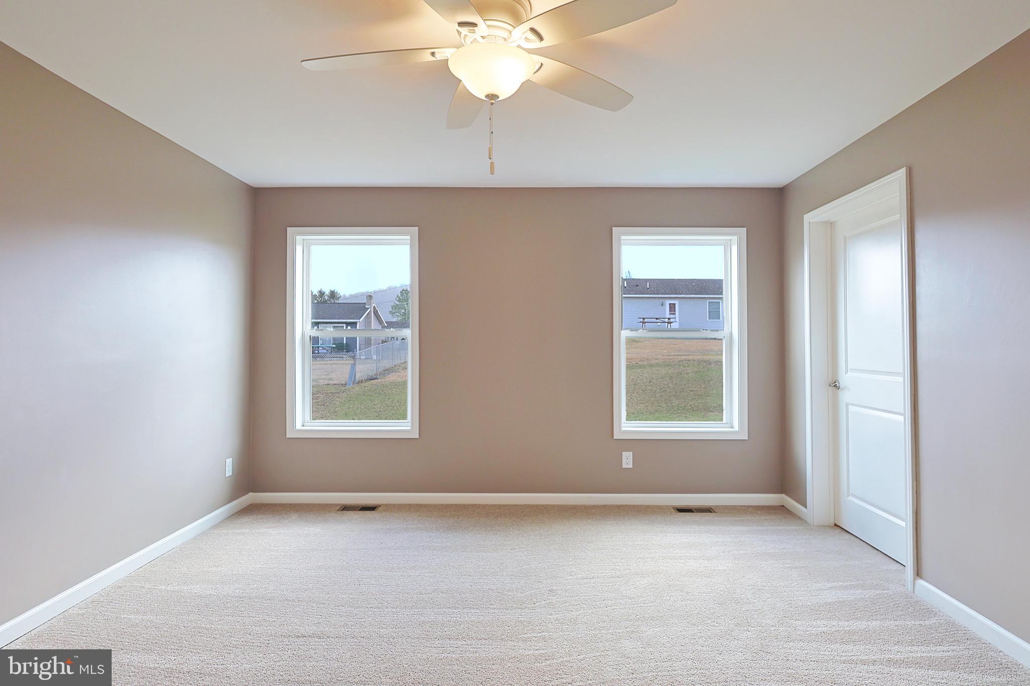 1525 Beacon Street Keyser, WV 26726 - Photo 30 of 59 an empty room with a chandelier fan and windows
