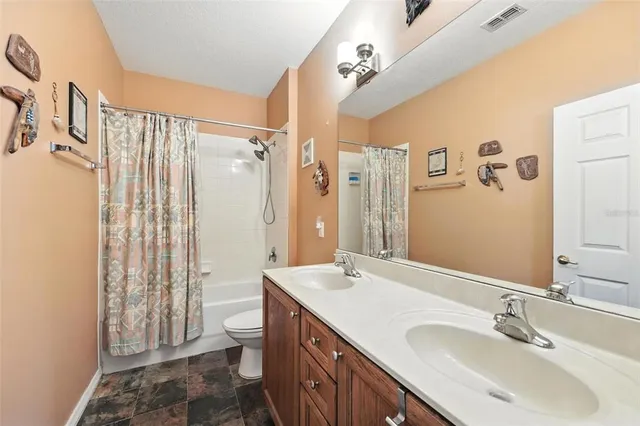 a bathroom with a double vanity sink toilet and shower