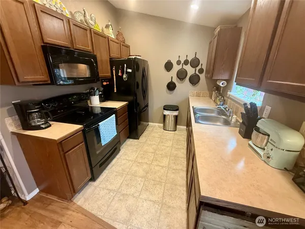 a living room with stainless steel appliances furniture a fireplace and a flat screen tv
