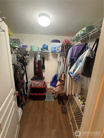 a view of walk in closet with clothes and shoes