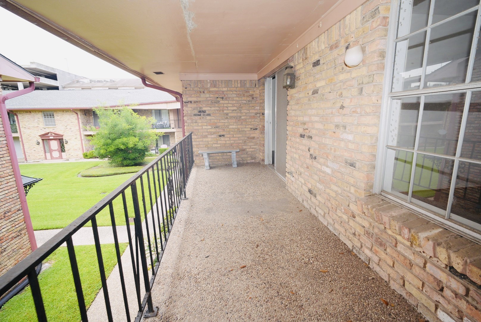 7600 Burgoyne Road, Unit 250 Houston, TX 77063 - Photo 12 of 14 Experience serene outdoor living on this charming balcony, perfect for relaxing and enjoying the picturesque courtyard views.