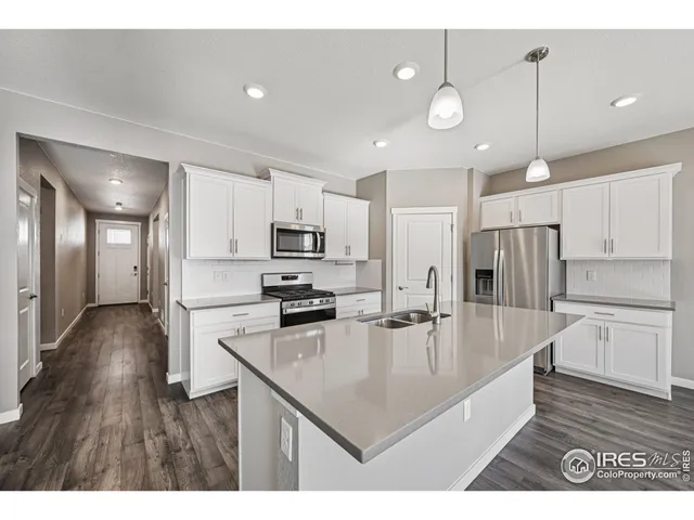 a kitchen with granite countertop a stove and a white cabinets