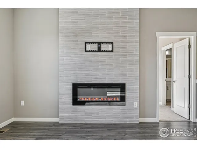 a view of kitchen and empty room with wooden floor