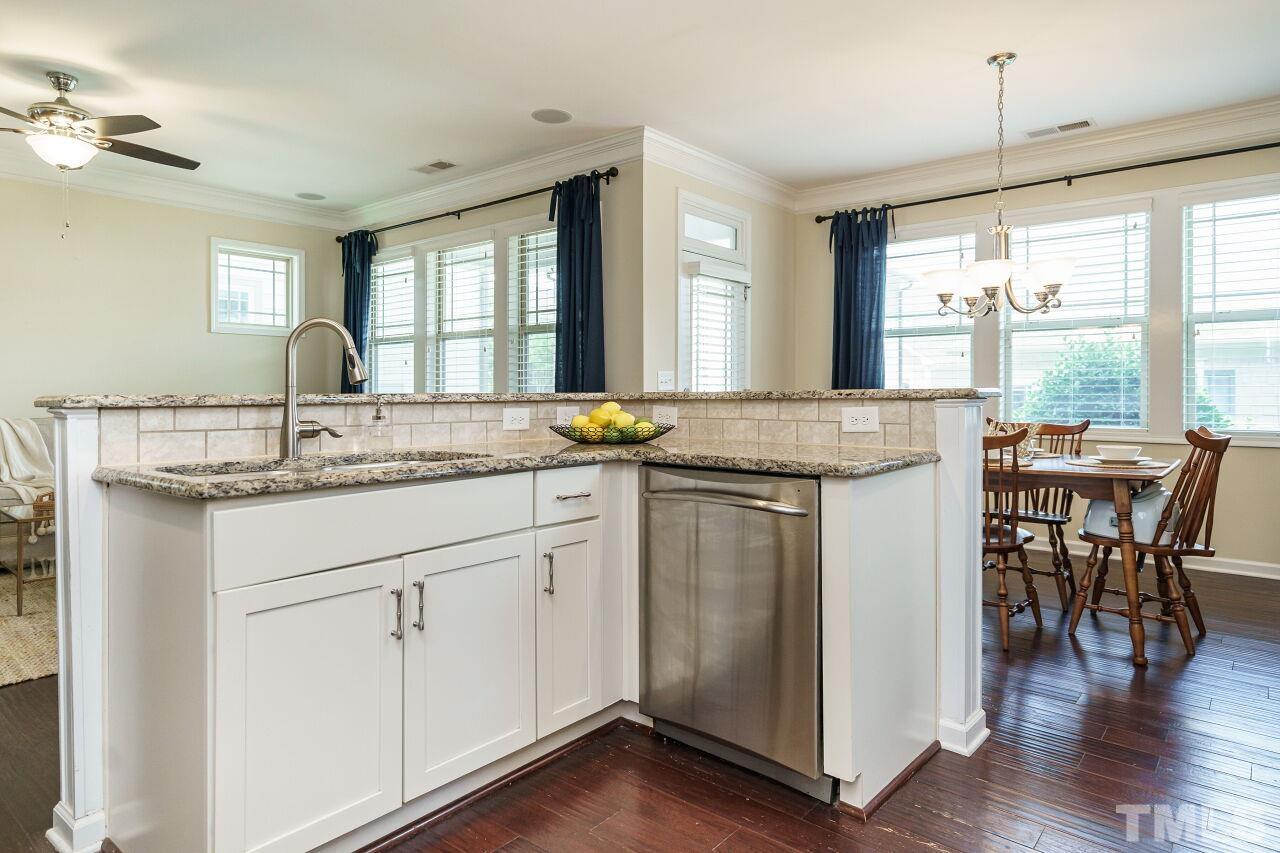 1568 Rodessa Run Raleigh, NC 27607 - Photo 12 of 25 a kitchen with granite countertop white cabinets and chairs