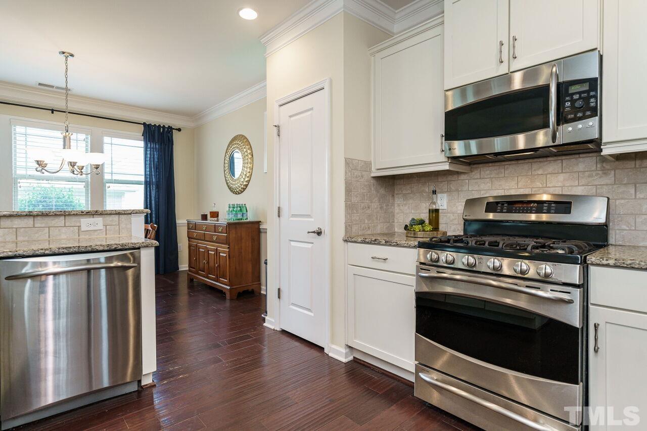 1568 Rodessa Run Raleigh, NC 27607 - Photo 13 of 25 a kitchen with stainless steel appliances a stove microwave and sink