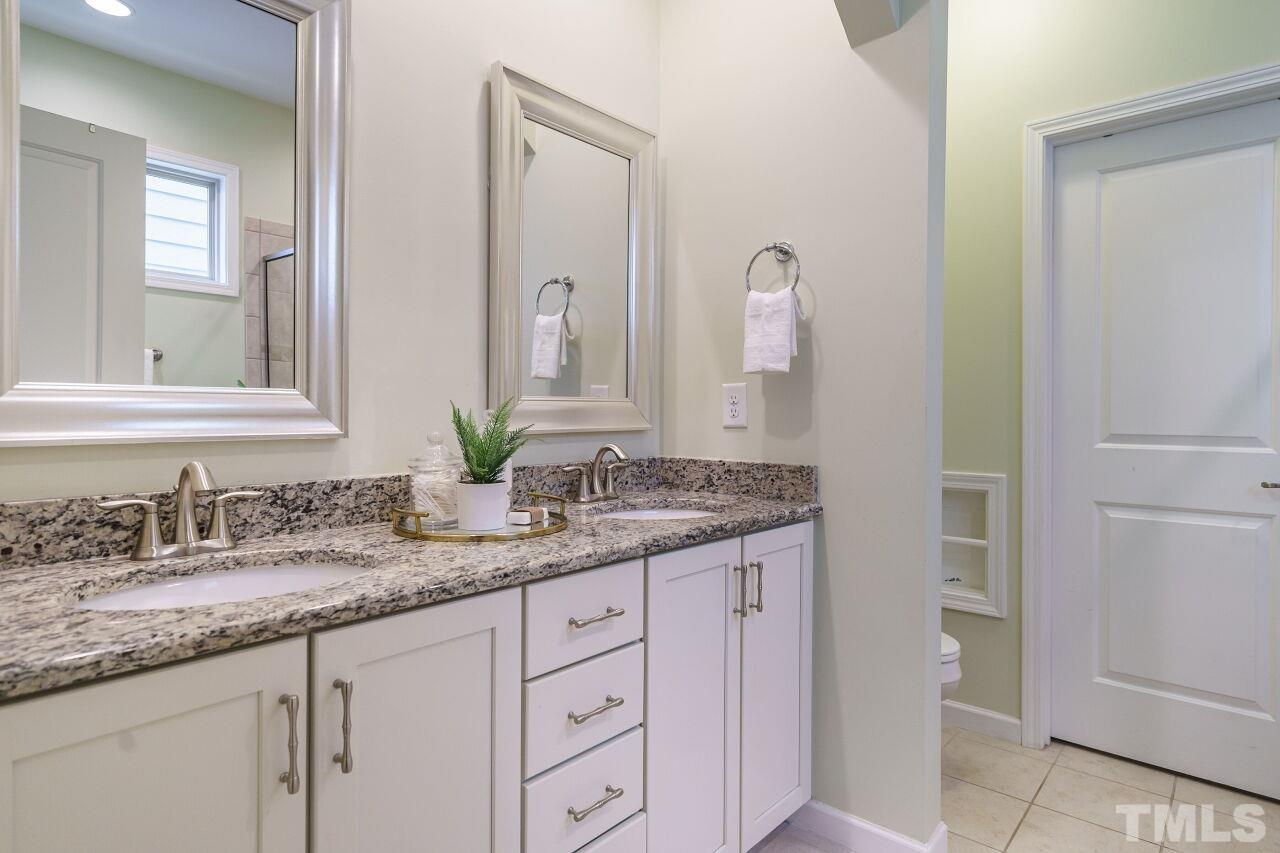 1568 Rodessa Run Raleigh, NC 27607 - Photo 16 of 25 a bathroom with a granite countertop sink and a mirror