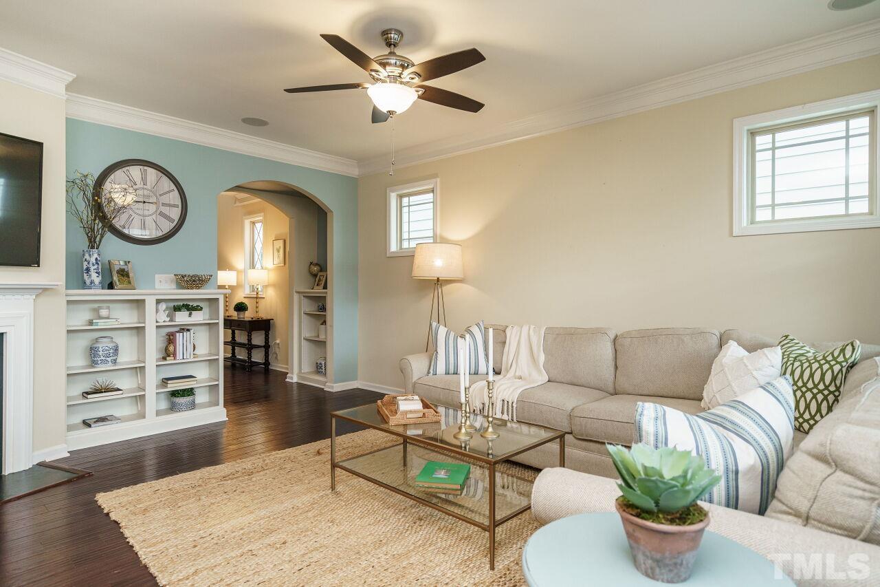 1568 Rodessa Run Raleigh, NC 27607 - Photo 6 of 25 a living room with furniture a clock on wall and a window