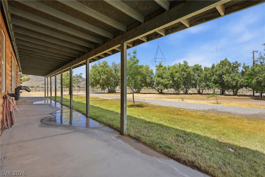 1531 West Harris Farm Road Pahrump, NV 89060 - Photo 14 of 37 A spacious covered porch offers scenic views of the surrounding natural landscape and distant hills.
