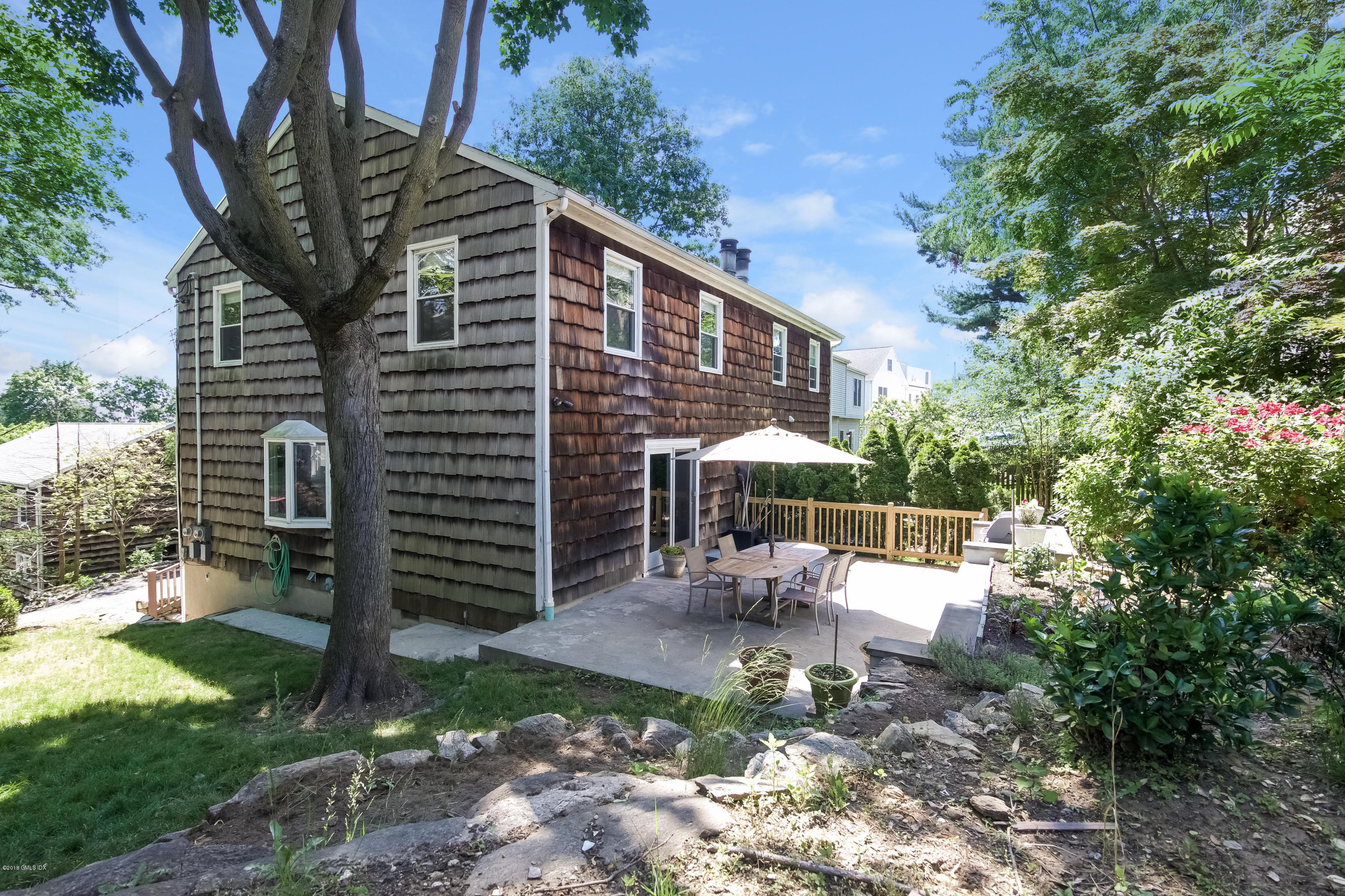 22 Livingston Place, Unit D Greenwich, CT 06830 - Photo 14 of 17 a view of a patio with table and chairs with wooden fence and plants