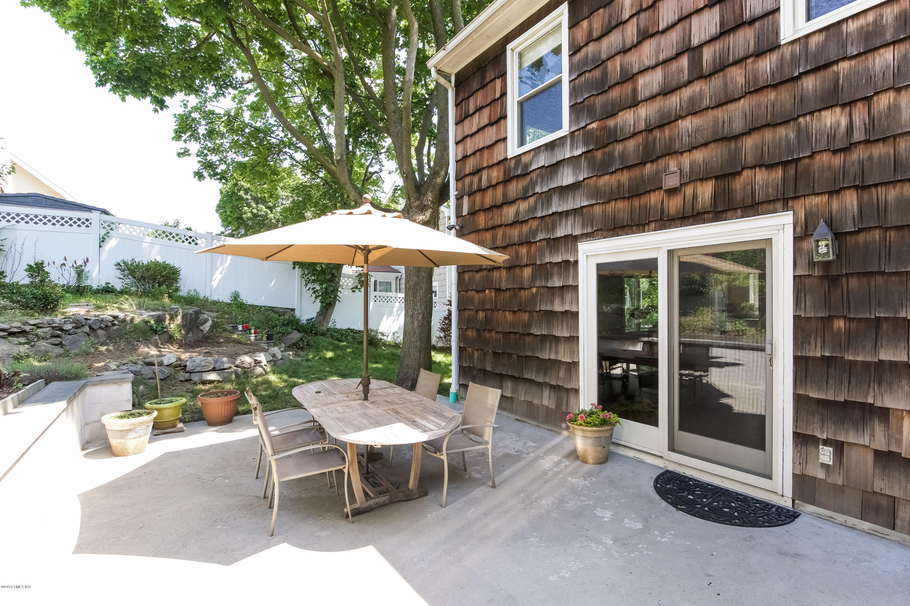 22 Livingston Place, Unit D Greenwich, CT 06830 - Photo 15 of 17 a view of a patio with a table and chairs under an umbrella