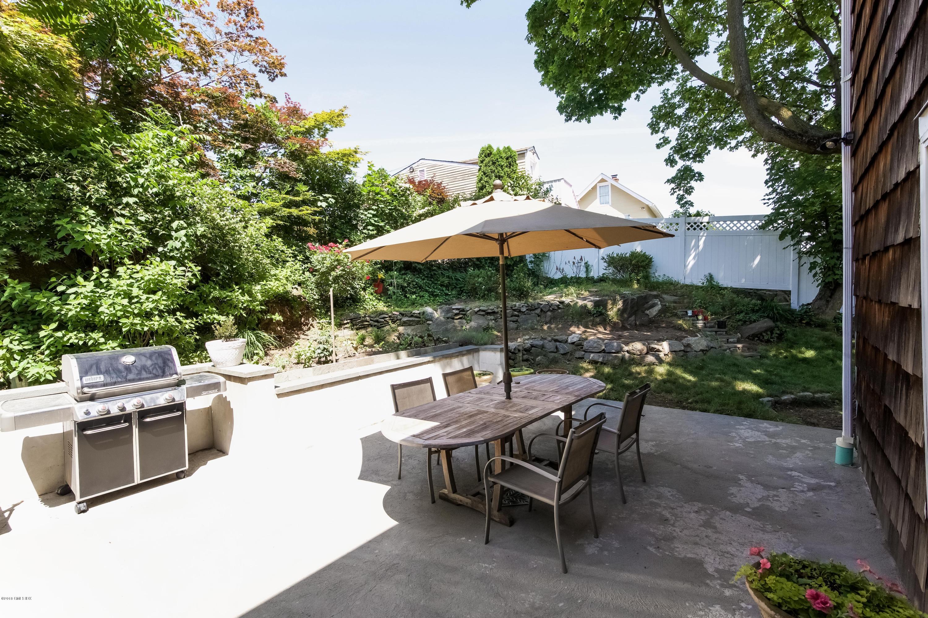 22 Livingston Place, Unit D Greenwich, CT 06830 - Photo 16 of 17 a view of a patio with a table and chairs under an umbrella