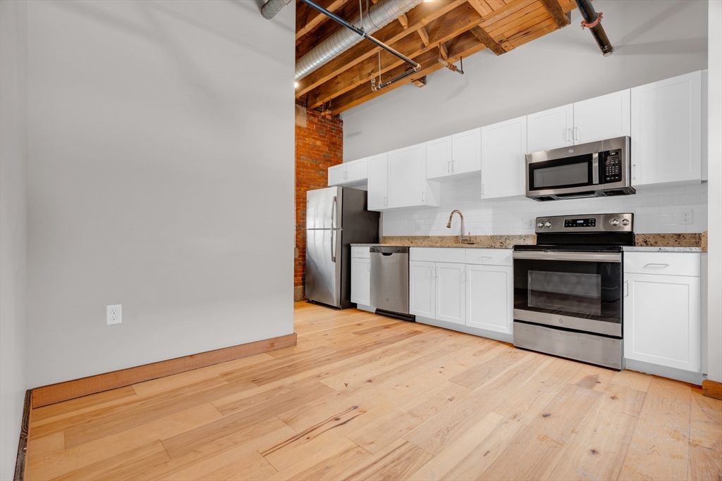 58 13th Street, Unit T105 Boston, MA 02129 - Photo 1 of 15 a kitchen with stainless steel appliances a stove top oven and cabinets