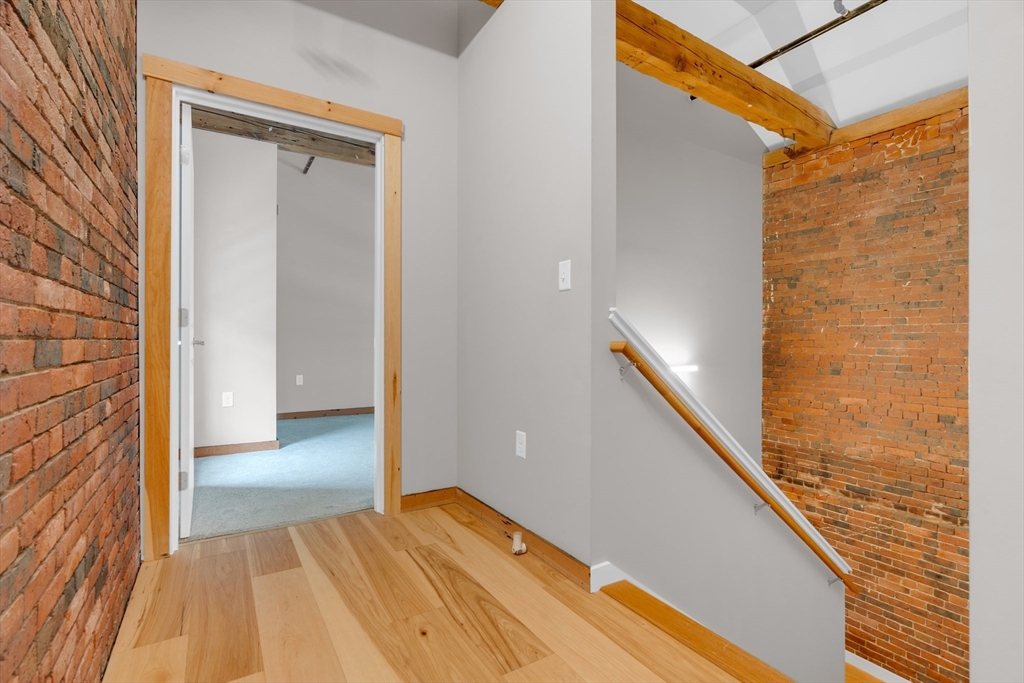 58 13th Street, Unit T105 Boston, MA 02129 - Photo 13 of 15 a view of a hallway with wooden floor and staircase