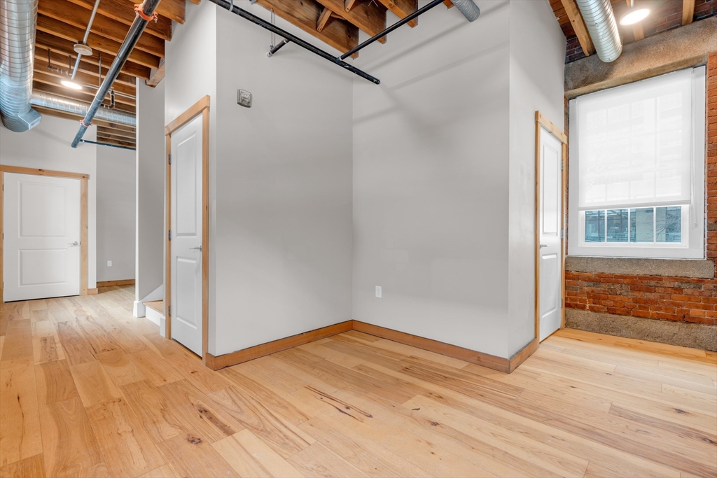 58 13th Street, Unit T105 Boston, MA 02129 - Photo 5 of 15 an empty room with wooden floor and windows