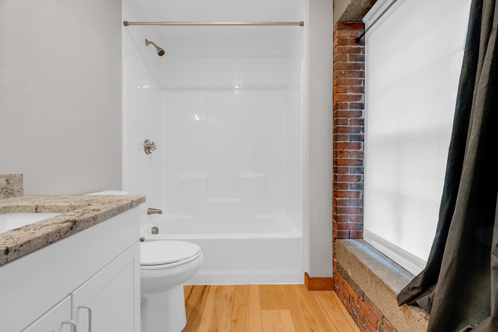 58 13th Street, Unit T105 Boston, MA 02129 - Photo 10 of 15 a bathroom with a granite countertop sink toilet and shower