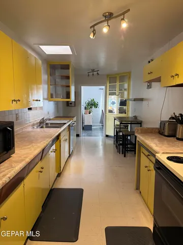 a kitchen with stainless steel appliances granite countertop a sink counter space and a stove top oven