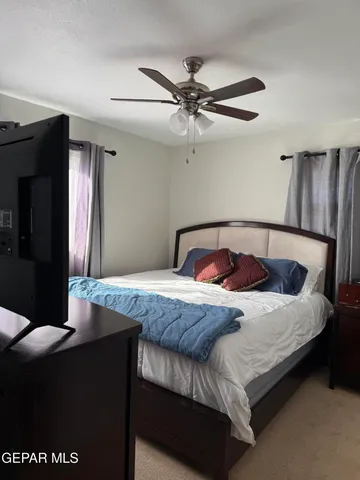 a bedroom with a bed and a ceiling fan