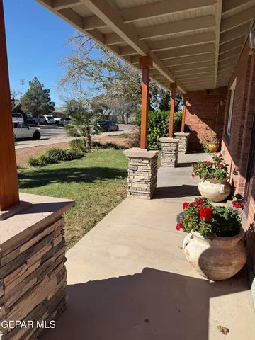 a view of a patio with a table and chairs and potted plants