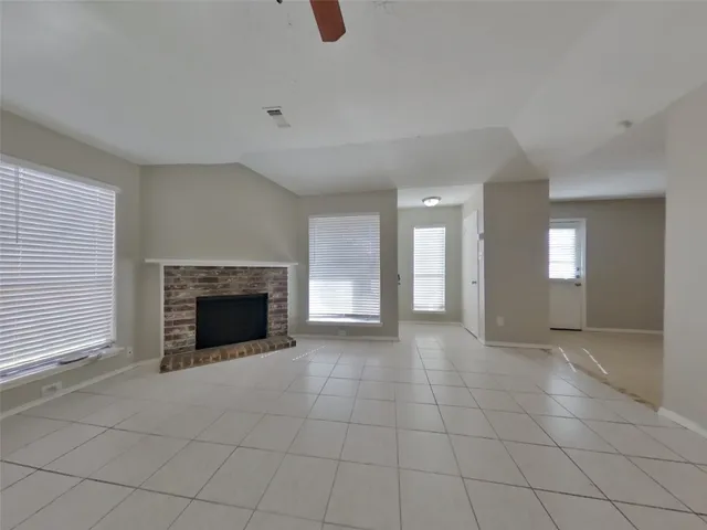 a view of an empty room with a fireplace and a window