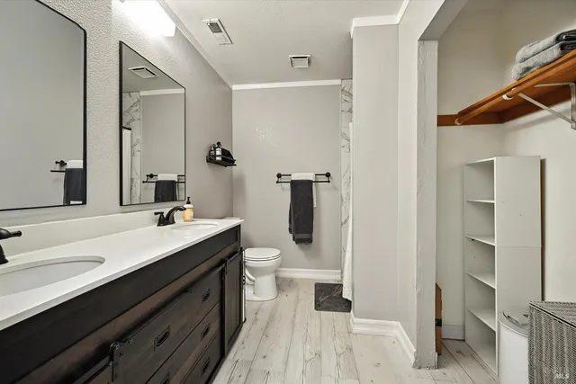 a bathroom with a sink a toilet and shower
