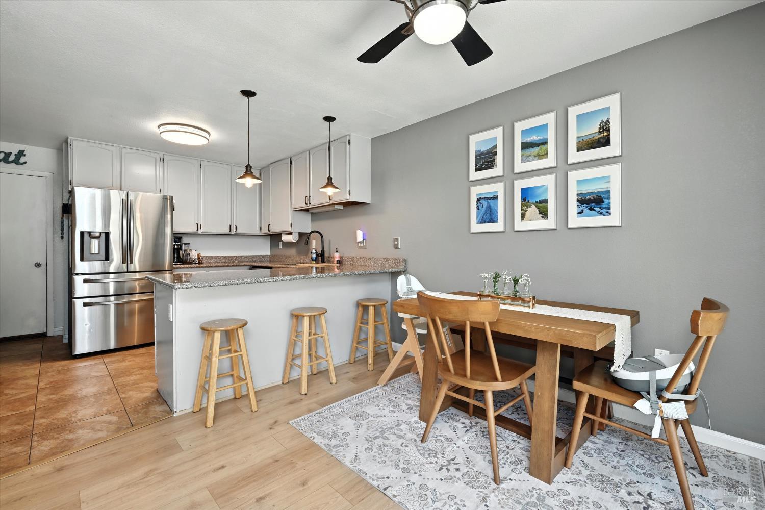 27 Fredrick Drive Rohnert Park, CA 94928 - Photo 6 of 26 a kitchen with stainless steel appliances kitchen island granite countertop a dining table chairs and white cabinets