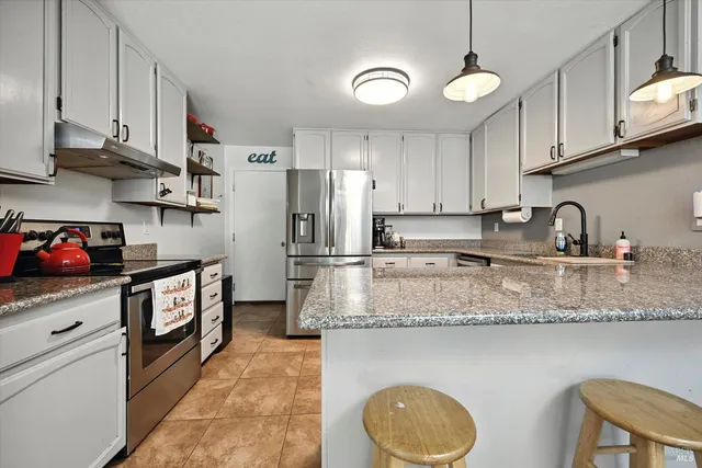 a kitchen with stainless steel appliances granite countertop a sink stove refrigerator granite counter tops and cabinets