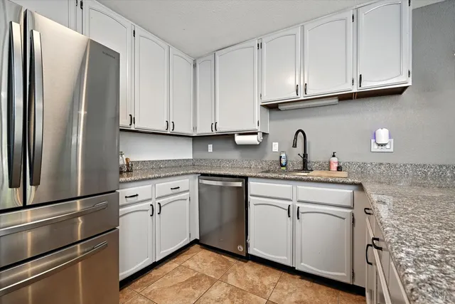 a kitchen with stainless steel appliances granite countertop a refrigerator sink and cabinets