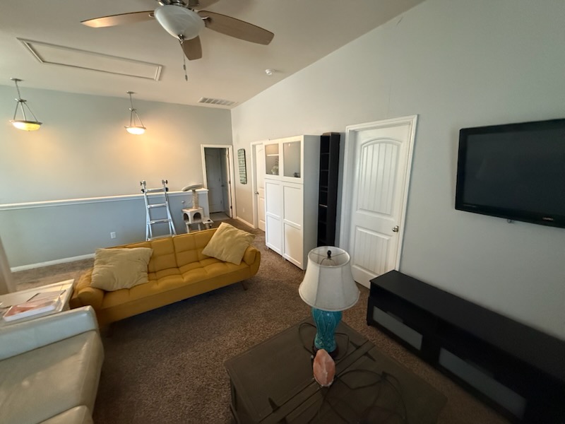 351 Wincliff Drive Buda, TX 78610 - Photo 22 of 25 Living room with a ceiling fan, dark colored carpet, and lofted ceiling