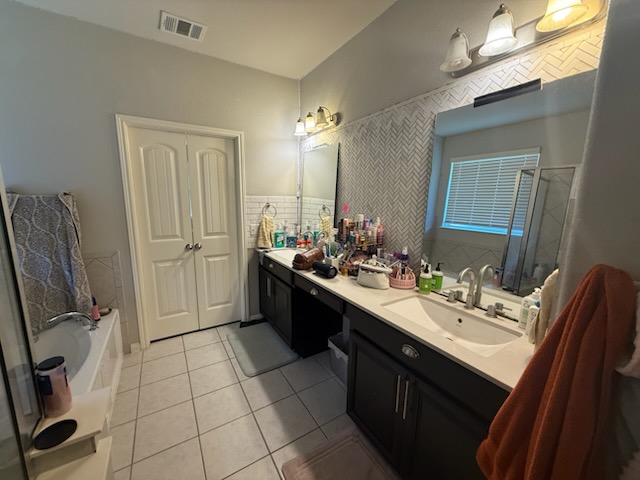 351 Wincliff Drive Buda, TX 78610 - Photo 24 of 25 Full bath with a bath, double vanity, light tile patterned floors, tile walls, and a stall shower