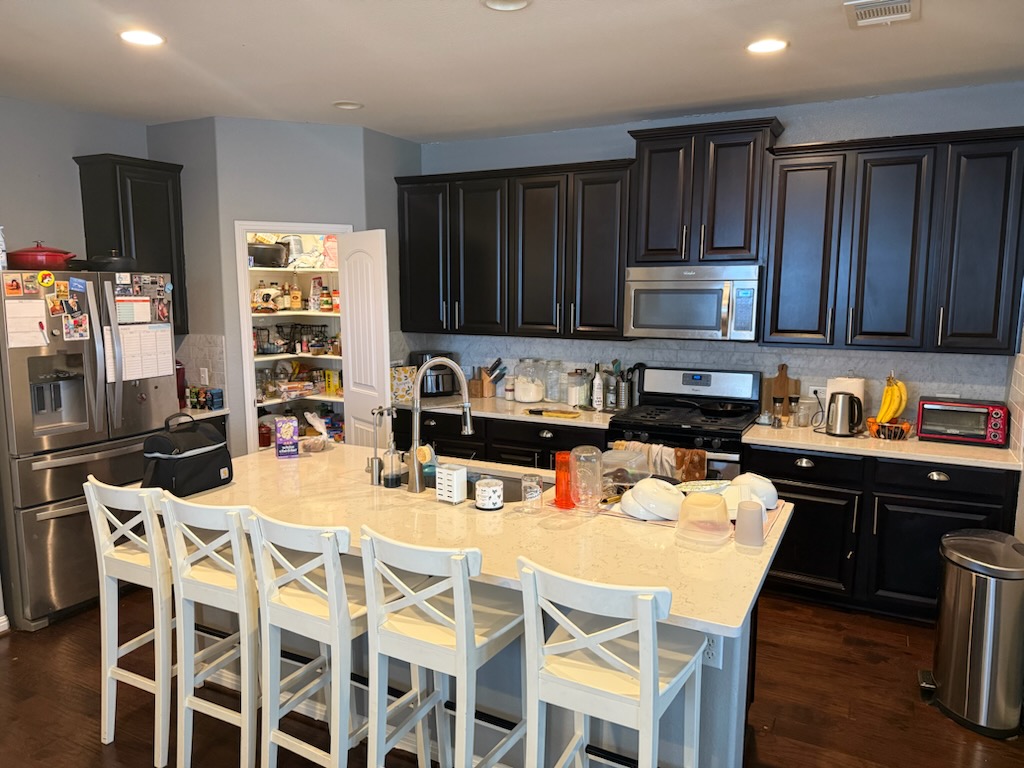 351 Wincliff Drive Buda, TX 78610 - Photo 8 of 25 Kitchen featuring stainless steel appliances, dark cabinets, light stone counters, tasteful backsplash, and recessed lighting