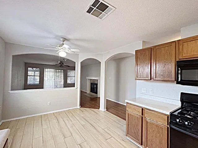 a kitchen with stainless steel appliances granite countertop a refrigerator oven a sink dishwasher and white cabinets with wooden floor