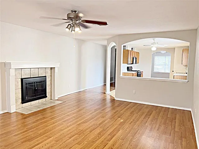 a view of a livingroom with wooden floor and a fireplace