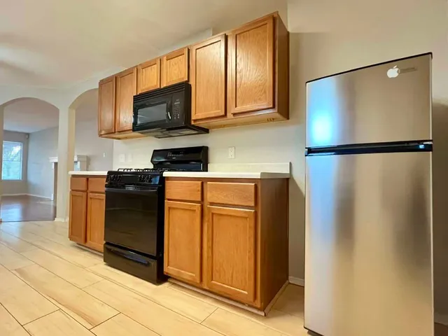 a kitchen with stainless steel appliances granite countertop a refrigerator and a stove top oven